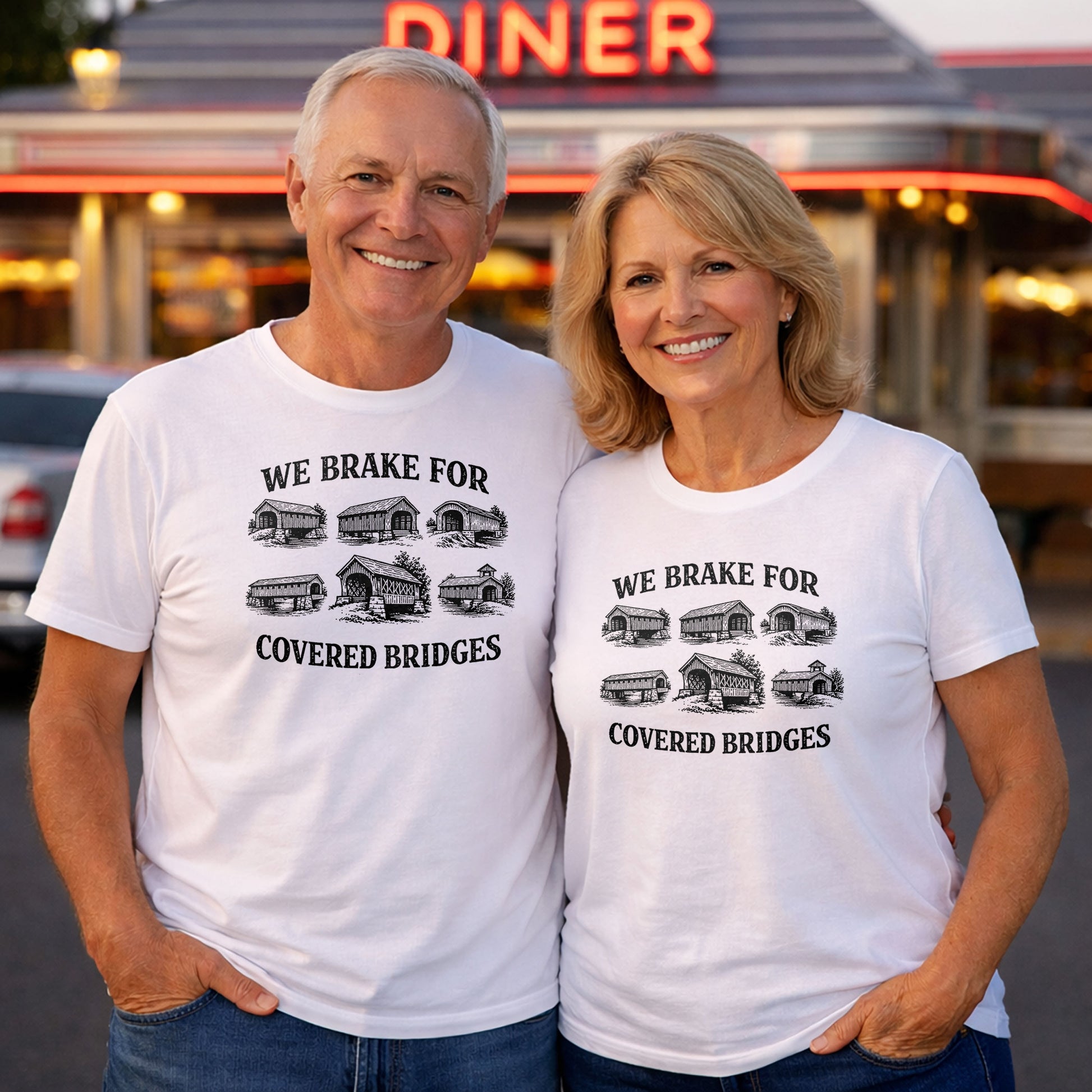 Older couple wearing white t-shirts with “We Brake For Covered Bridges” Indiana design standing outside a vintage diner in a nostalgic setting