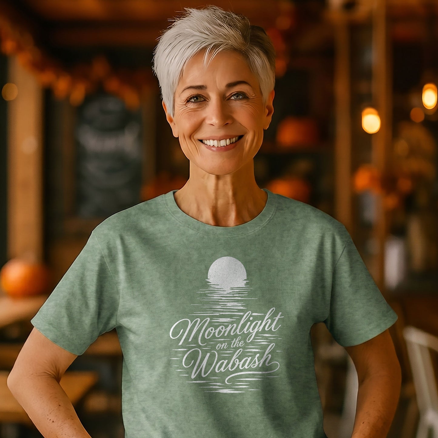 Woman wearing a Moonlight on the Wabash Indiana Comfort Colors t-shirt featuring vintage moonlit river artwork and script lettering.