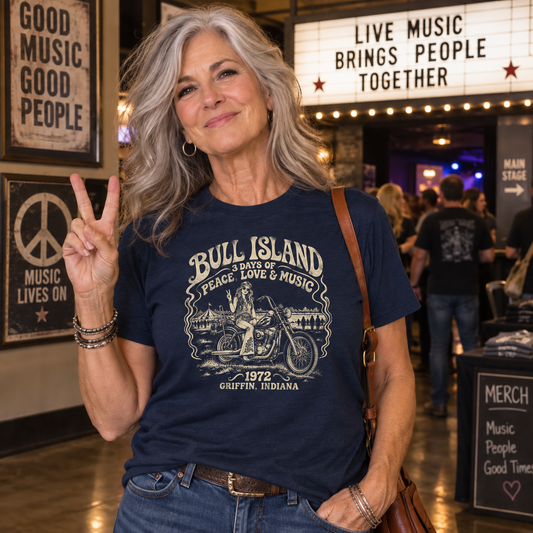 Woman wearing a navy Comfort Colors T-shirt featuring the vintage Bull Island 1972 Griffin Indiana music festival design.