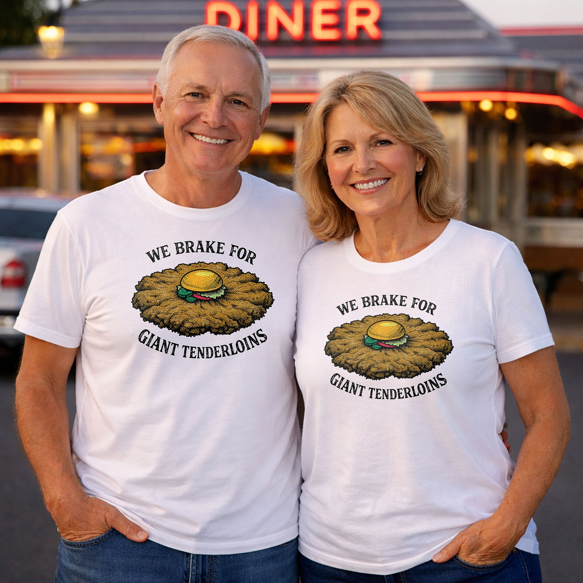 Couple wearing white We Brake For Giant Tenderloins t shirts standing outside classic American diner