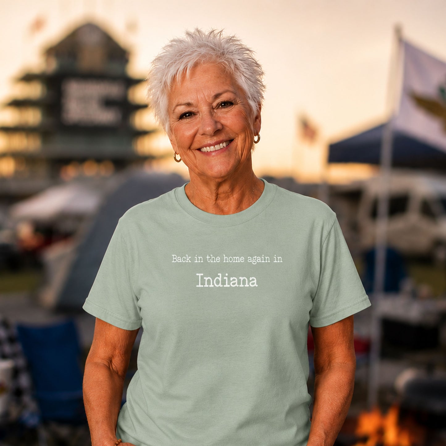 Older woman wearing a mint green “Back in the Home Again in Indiana” funny Hoosier humor t-shirt while camping outside the Indianapolis Motor Speedway at sunset.