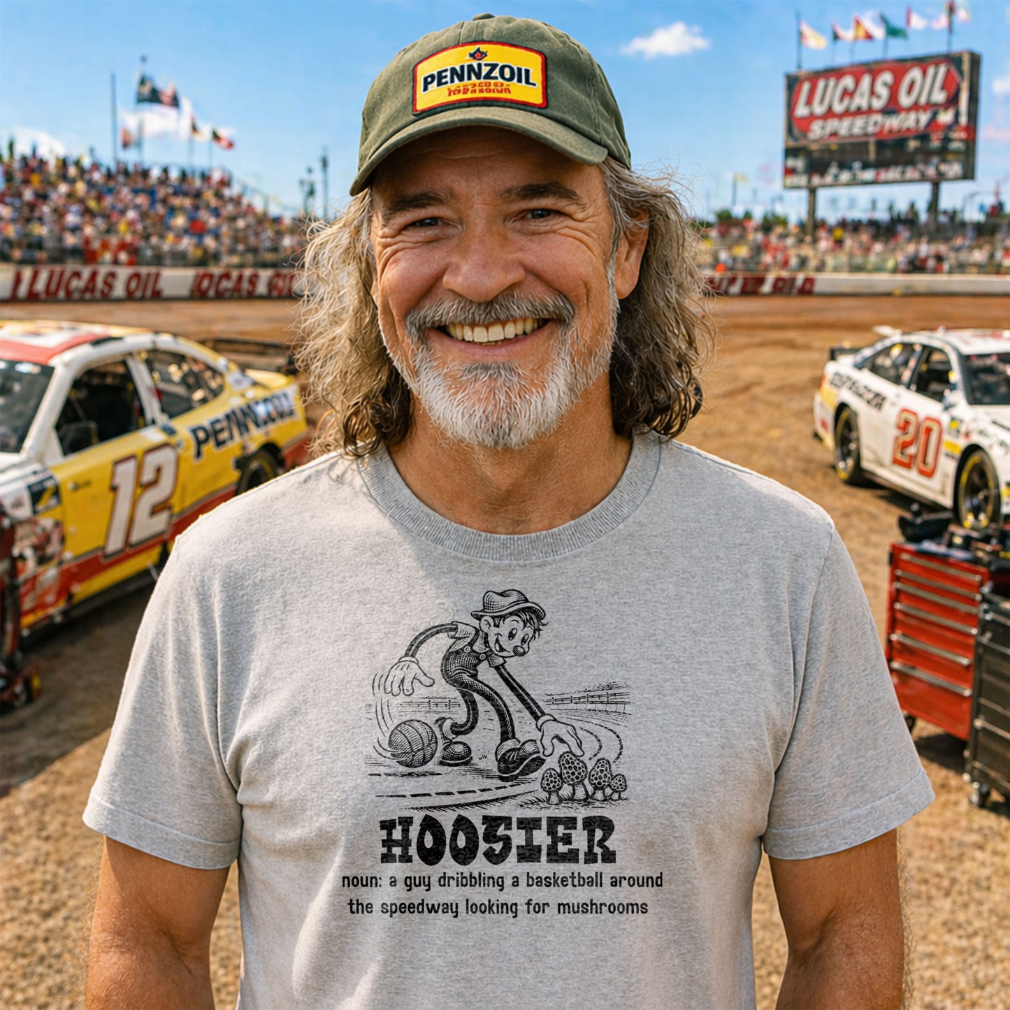 Man wearing a cap and t-shirt with a humorous definition of 'Hoosier' at a race track.
