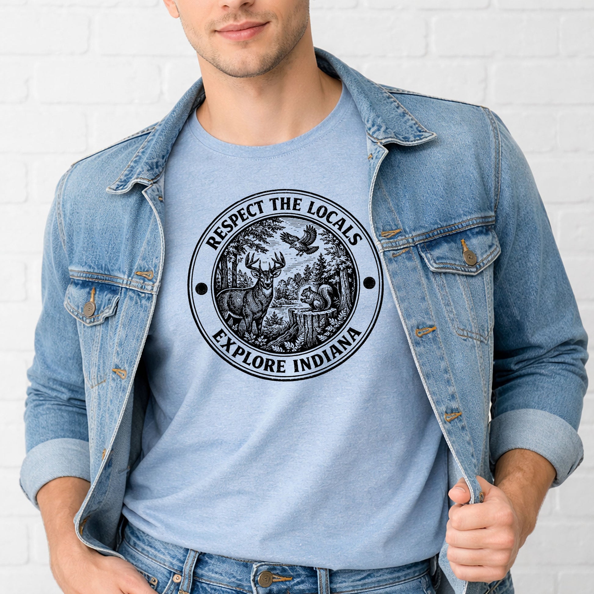 man wearing respect the locals indiana shirt near forest or lake outdoor setting