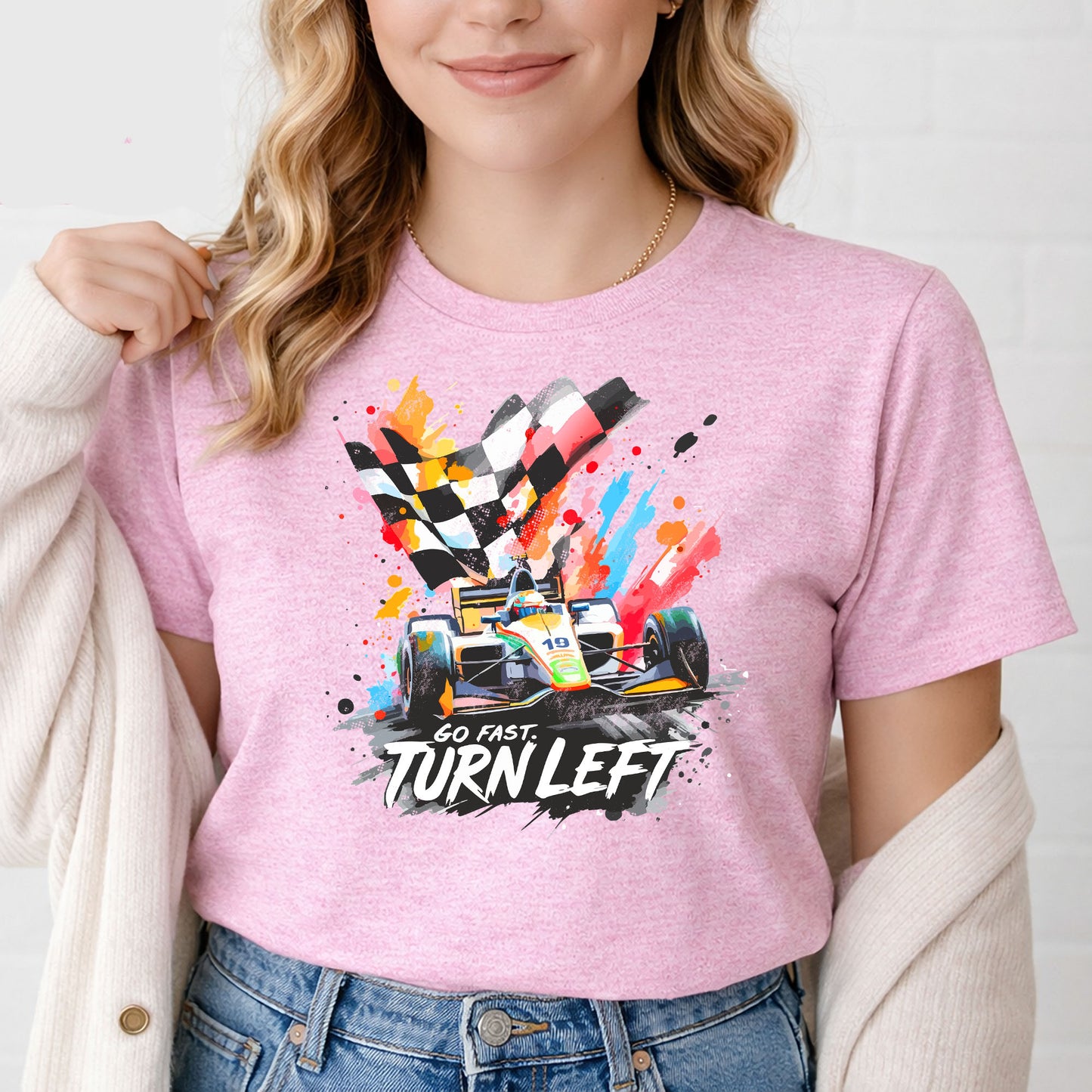 Female model wearing colorful Indy racing t-shirt against white brick background