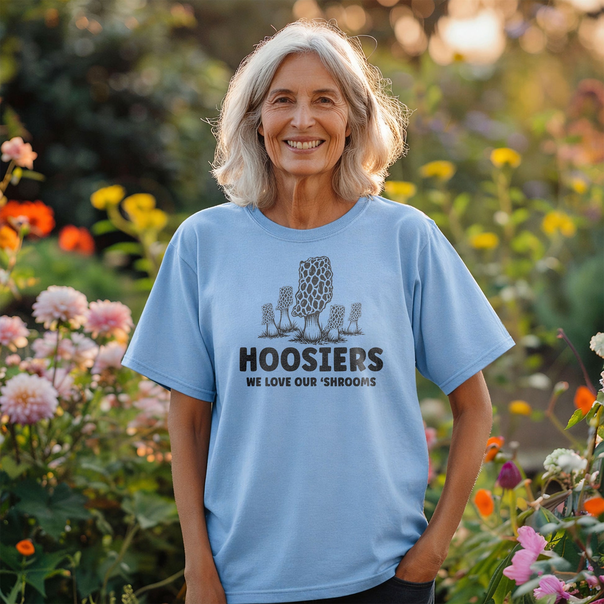 Smiling woman wearing Hoosiers mushroom t-shirt standing in colorful garden setting