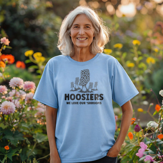 Smiling woman wearing Hoosiers mushroom t-shirt standing in colorful garden setting