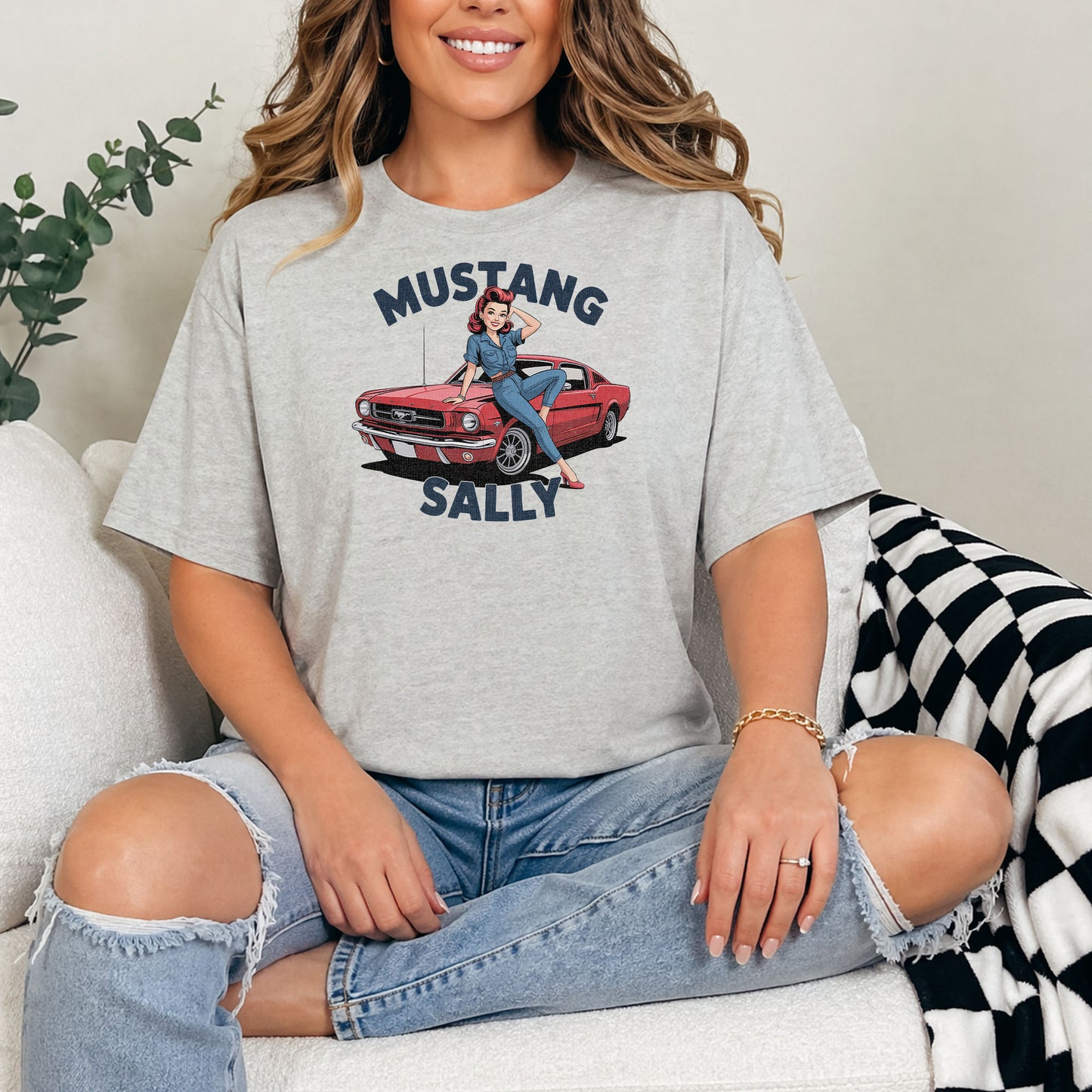 Female model wearing retro muscle car t-shirt with pinup design against white brick wall