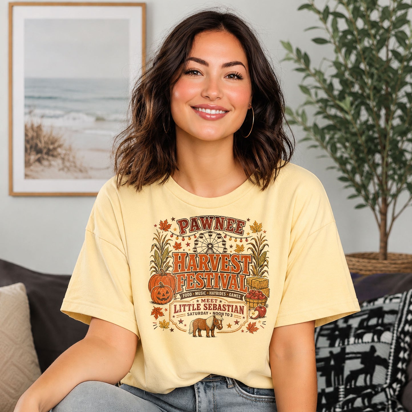 Woman wearing a Pawnee Harvest Festival Indiana-inspired Comfort Colors t-shirt featuring pumpkins, carnival rides, autumn decorations, and Little Sebastian.