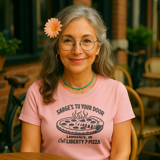 woman in pink sarges pizza tee smiling at cafe table lifestyle photo