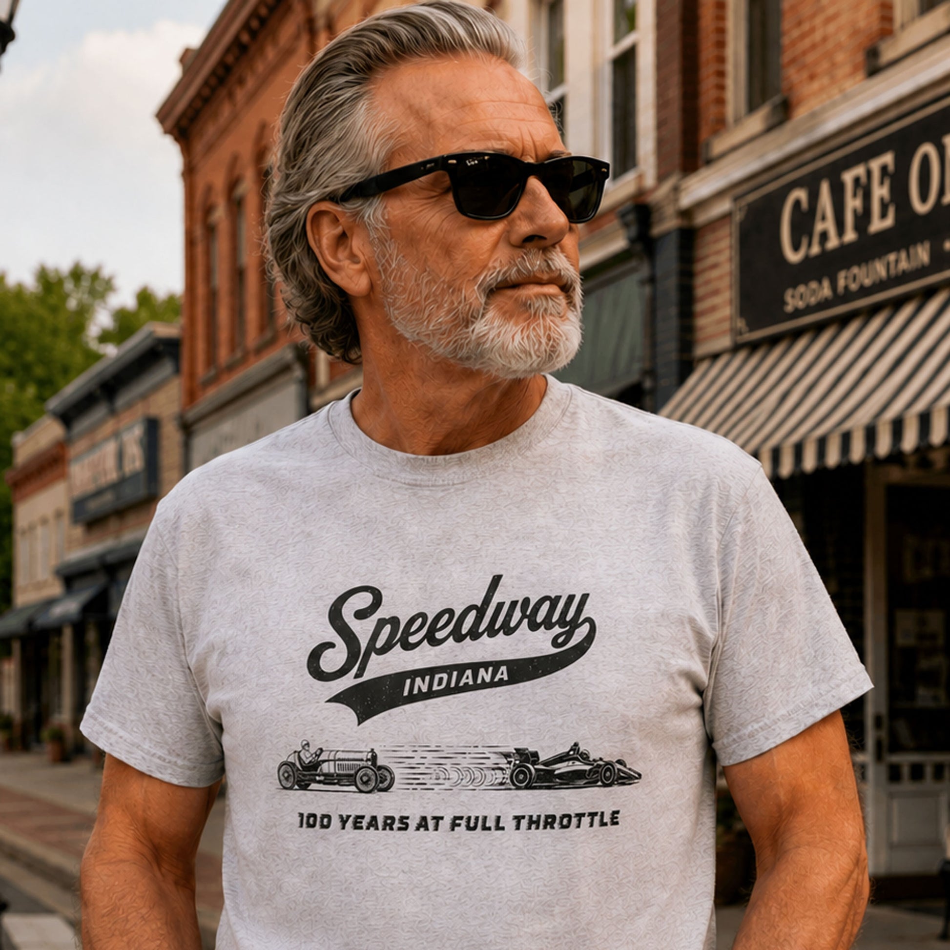 Older male model wearing a Speedway Indiana 100 Years at Full Throttle racing T-shirt on a small-town Indiana street.