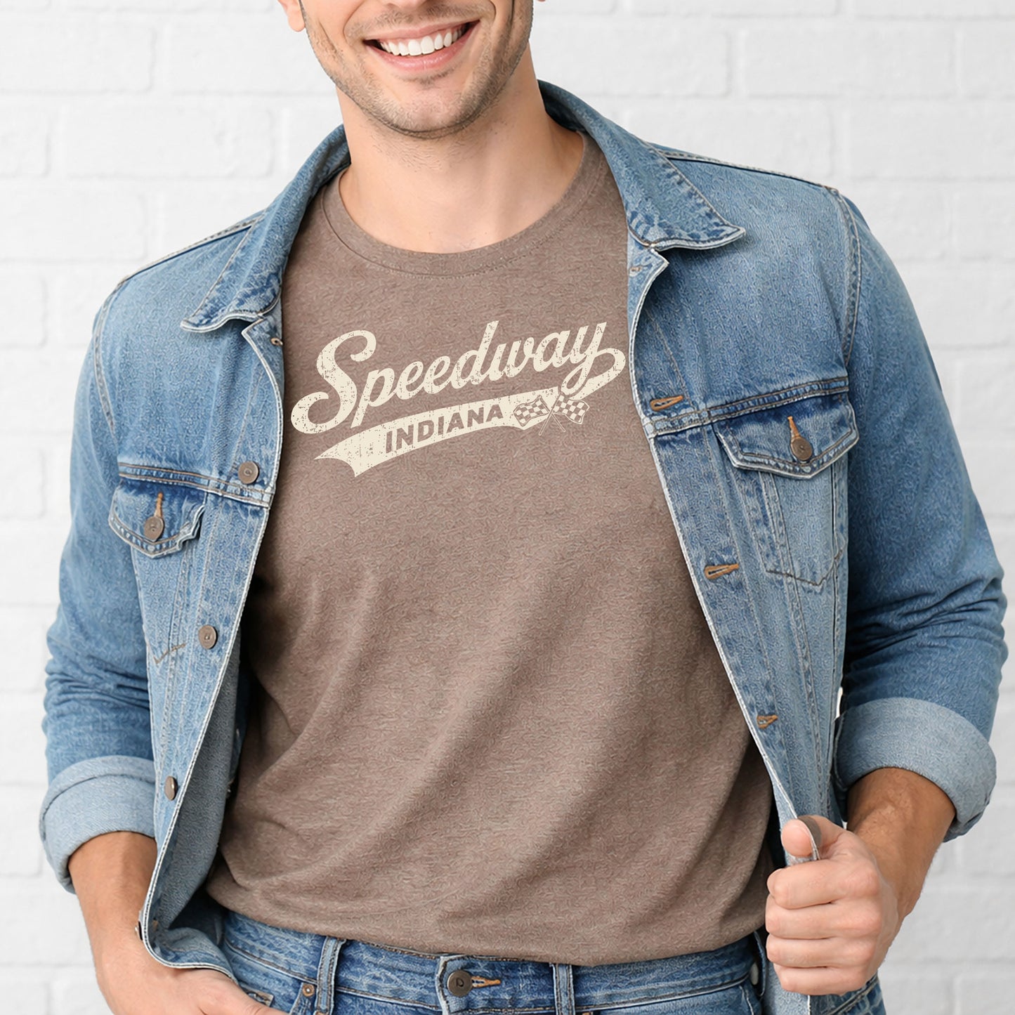 Male model wearing Speedway Indiana racing shirt standing in front of white brick wall